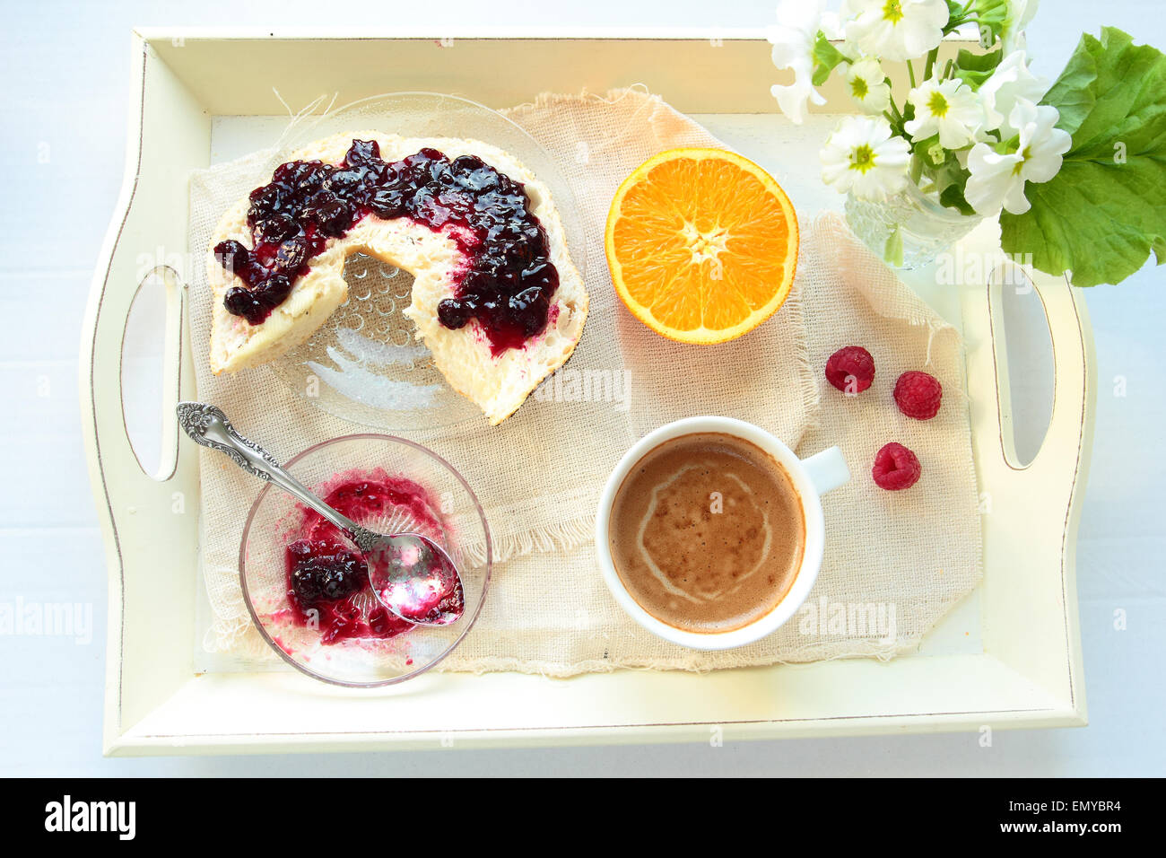 Tablett mit Frühstück. Roll mit Johannisbeeren Marmelade und eine Tasse Kaffee Stockfoto