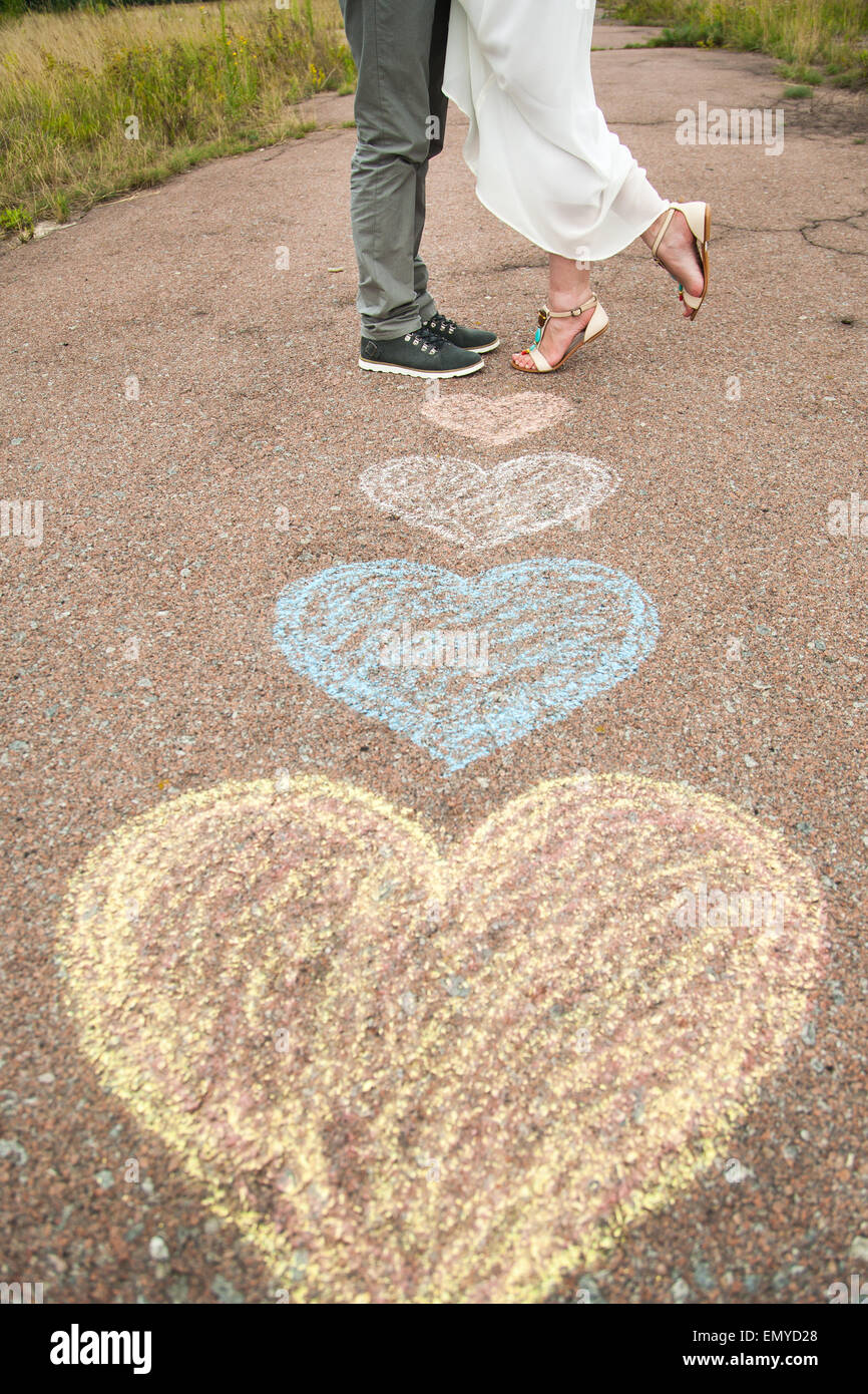 Herz Symbole geformt mit Buntstiften auf Boden und zwei verliebte. Lifestyle und Gefühle Konzept. Stockfoto