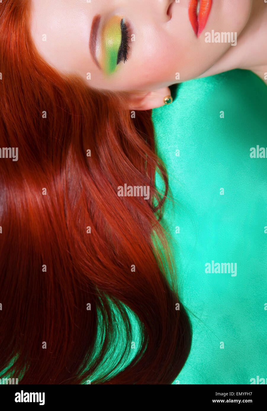Porträt von rothaariges Mädchen mit hellen Make-up auf grünem Hintergrund Stockfoto
