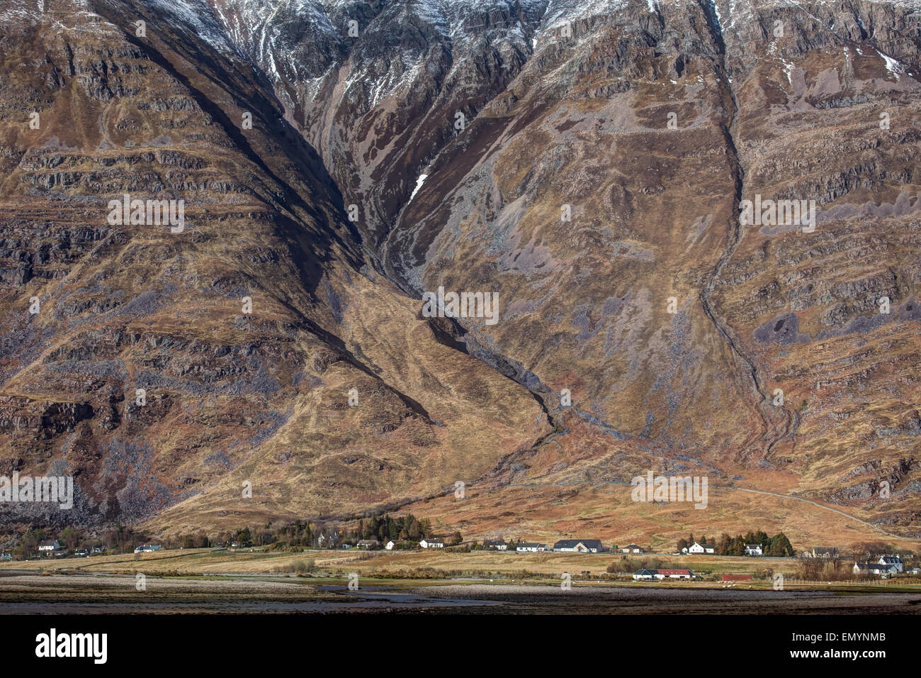 kleines Dorf im Norden Schottlands eingebettet unter einem Berg Stockfoto