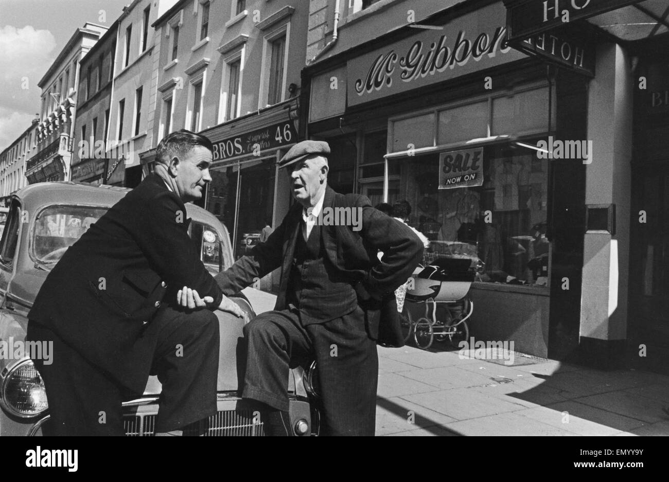 Herren hier außerhalb der Hauptparade Geschäfte in Lurgan, holt die Lokalnachrichten zu sehen. Ca. 1966 Stockfoto