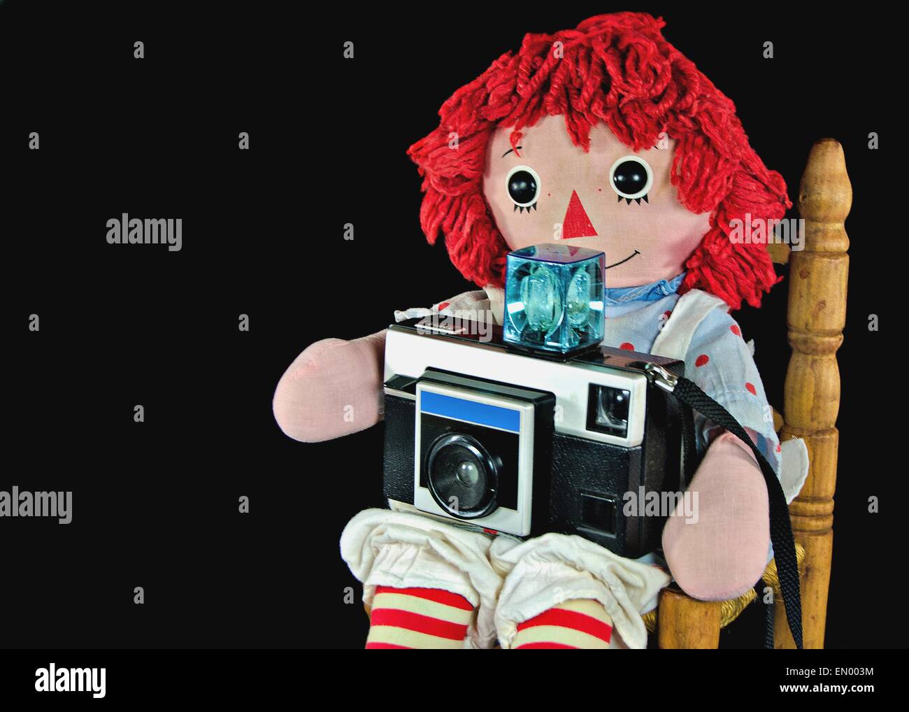 Alte Stoffpuppe mit Retro-Kamera. Stockfoto