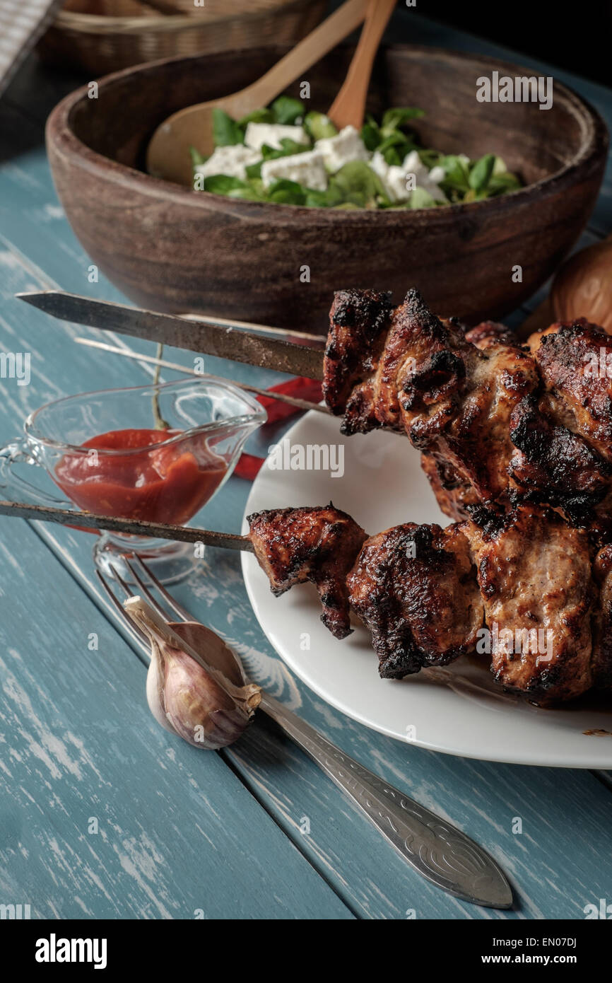 Schaschlik mit Salat auf dem Holztisch Stockfoto