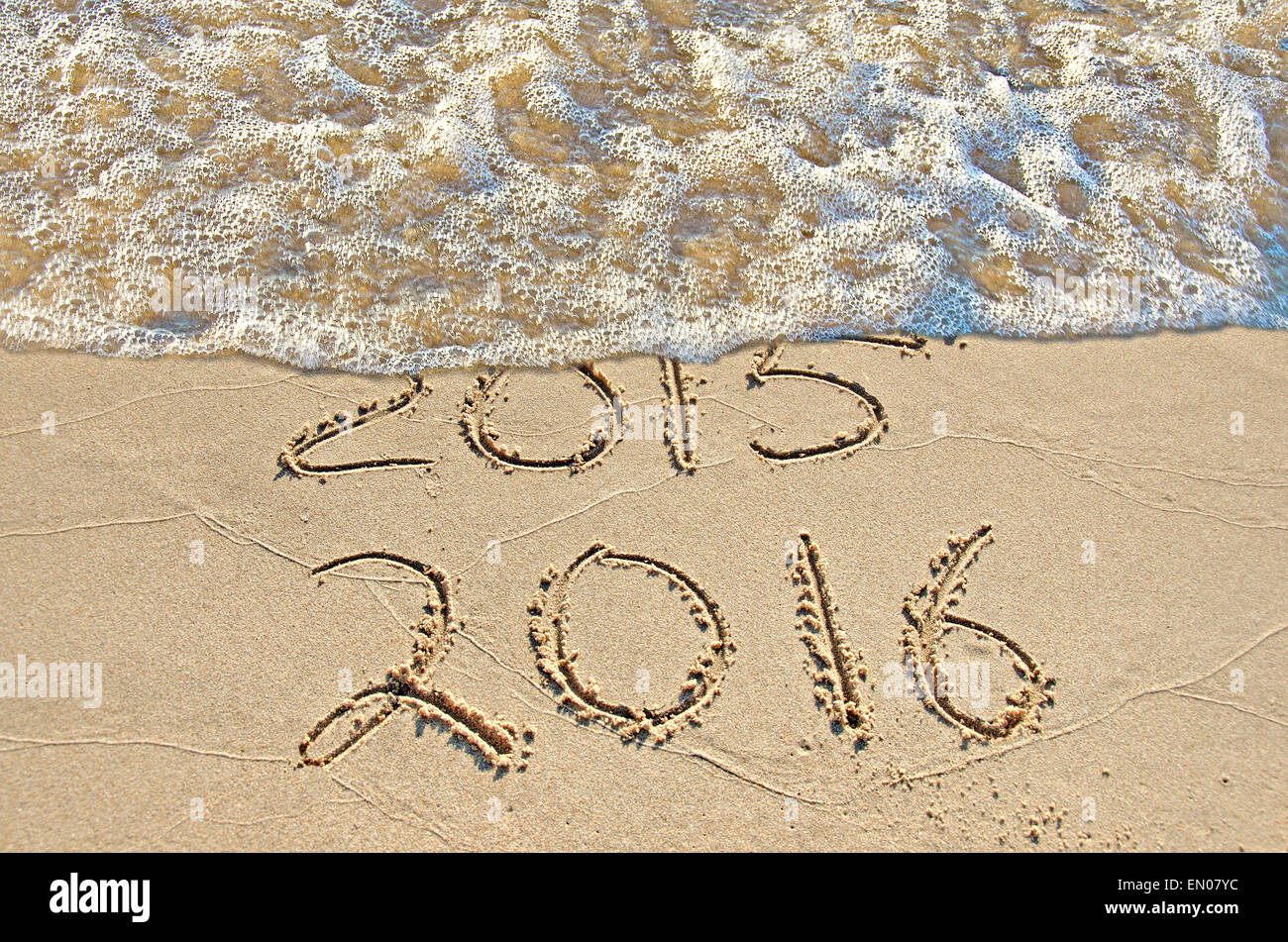 Neues Jahr 2016 im Strandsand mit Schampus Surf löschen altes Jahr 2015 geschrieben. Stockfoto