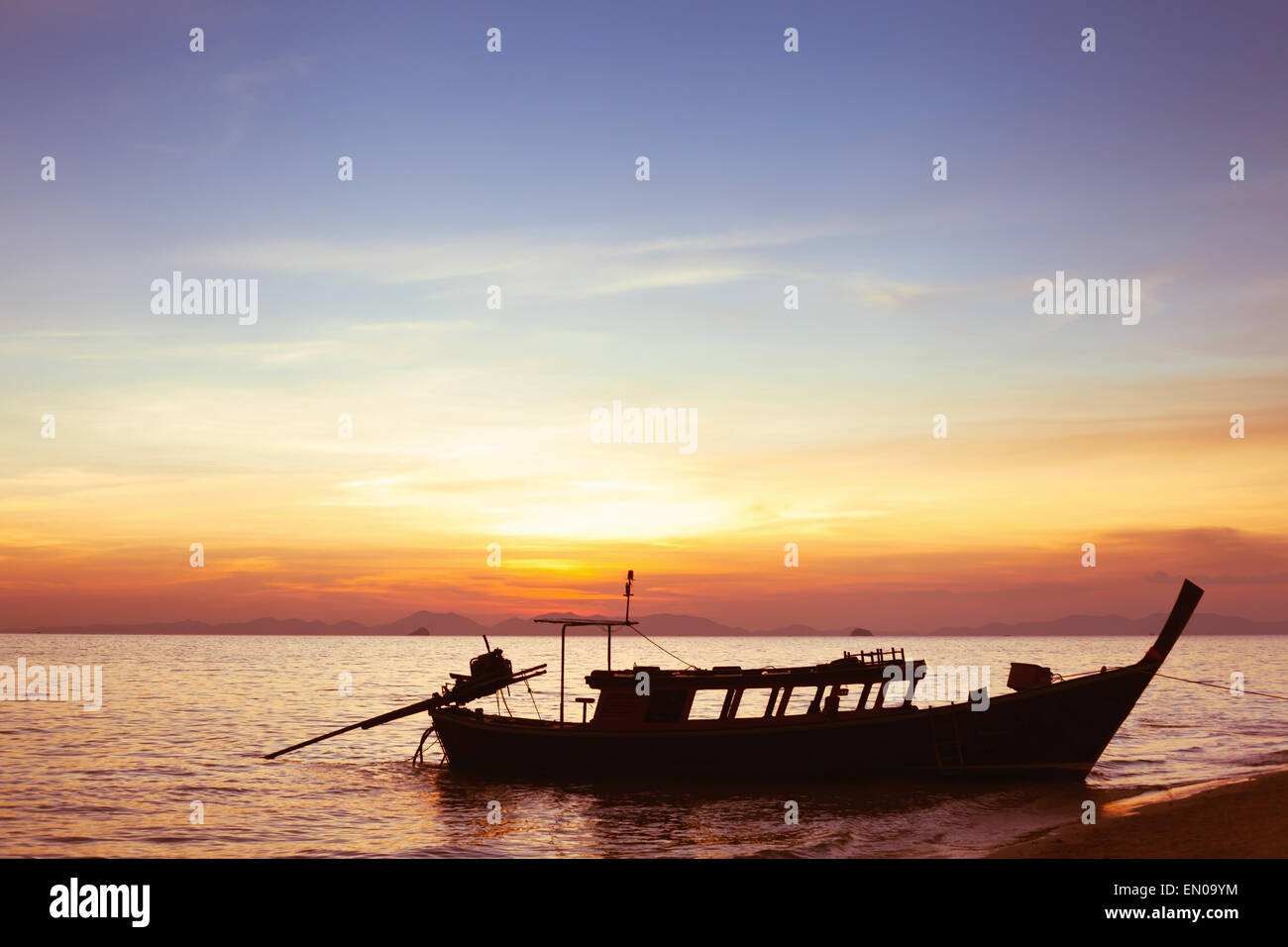 Sonnenuntergang am Strand mit Silhouette des Bootes Stockfoto