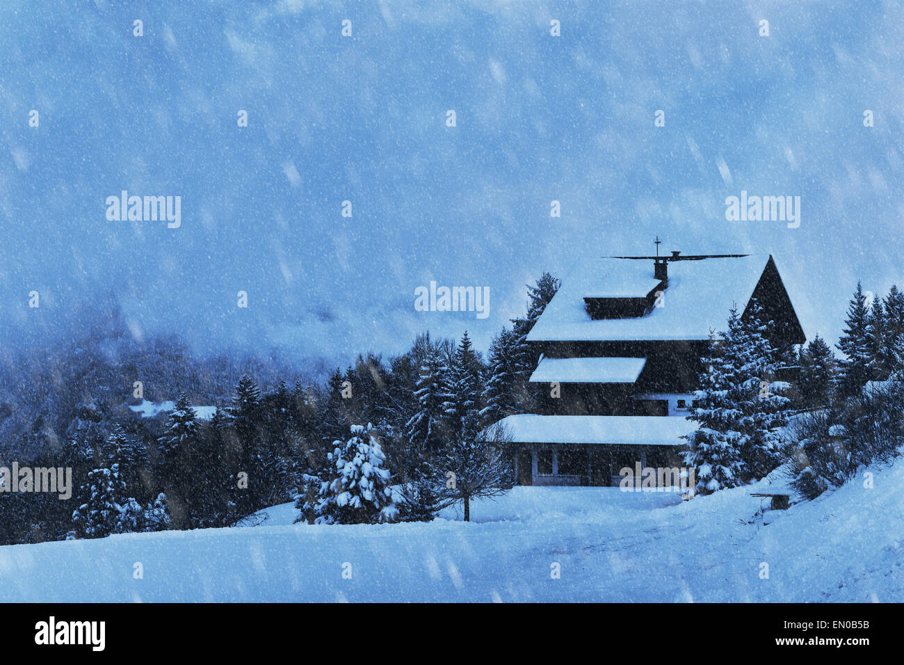 Schneefall und Holzhaus im Wald, Winter Hintergrund Stockfoto