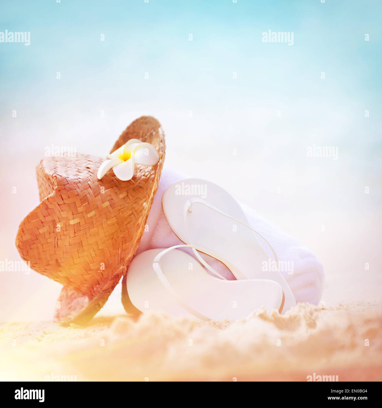 Sommer-Ferien-Hintergrund, Nahaufnahme Foto von stilvollen Strandzubehör an sandigen Küste, schönen Strohhut weißen Flip-Flops Stockfoto