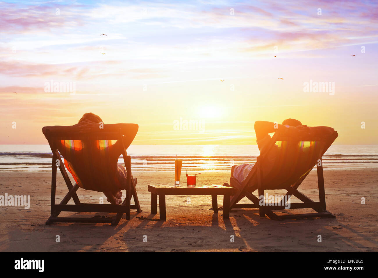 glückliches Paar genießen Sie Luxus-Sonnenuntergang am Strand in den Sommerferien Stockfoto