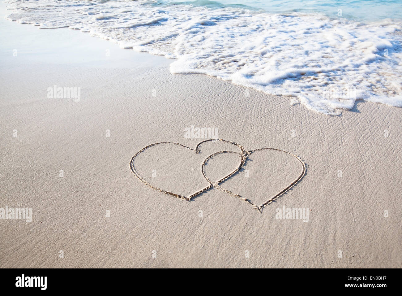 zwei Herzen gezogen auf perfekt weißen Sand von Paradise beach Stockfoto