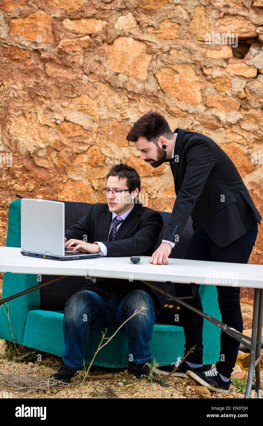Zwei Jungs um einen Schreibtisch in einem Grunge-Büro, ein Konkurs-Konzept Stockfoto