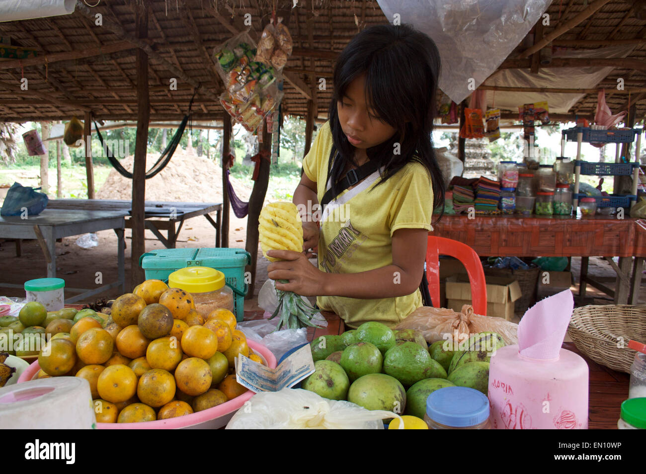 Kambodschanische Mädchen gekonnt schnitzen eine Ananas am an Obst stand. Stockfoto