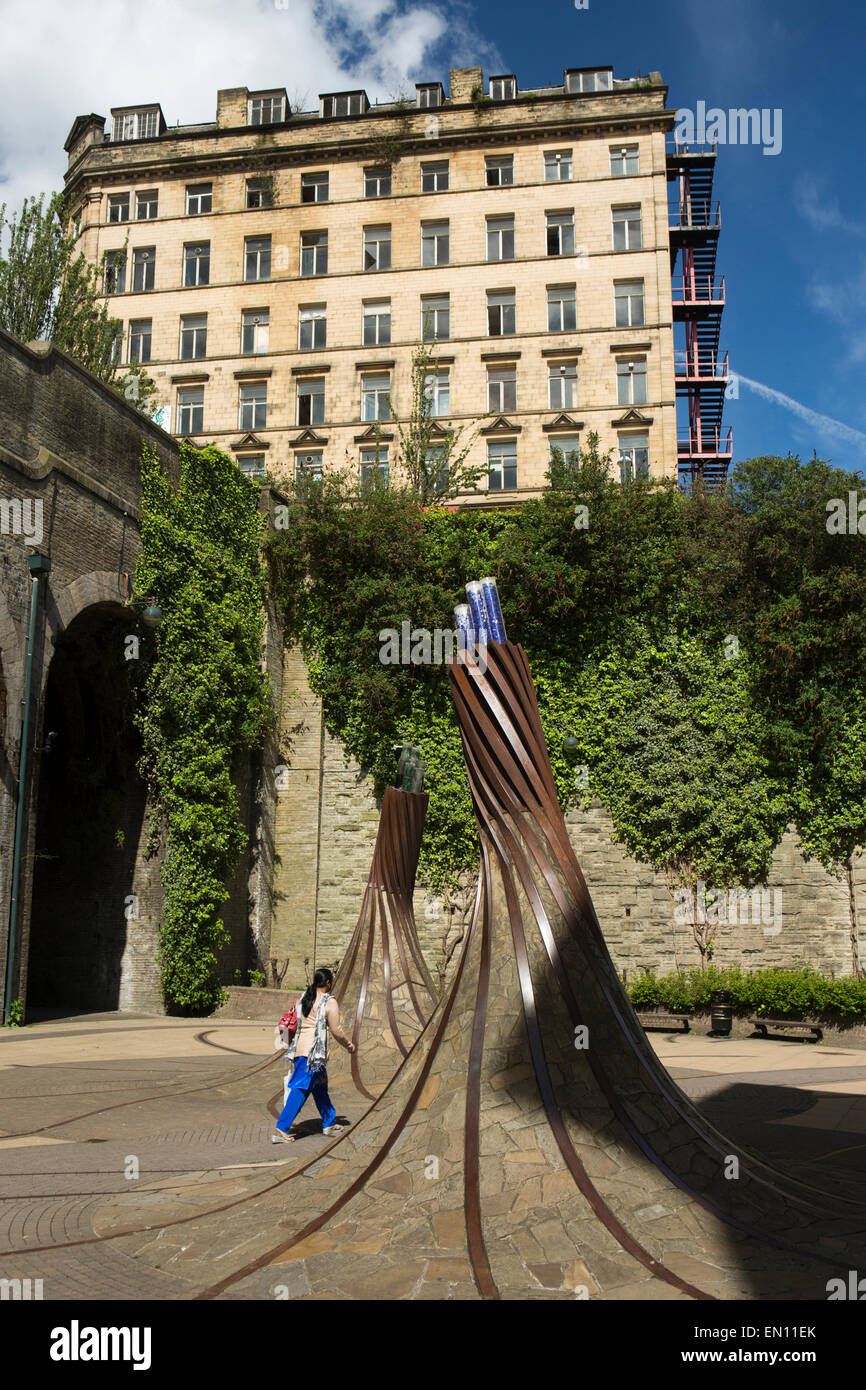 Großbritannien, England, Yorkshire, Bradford, Forster Square, Frau zu Fuß zwischen verdrehten Schiene Skulpturen Stockfoto