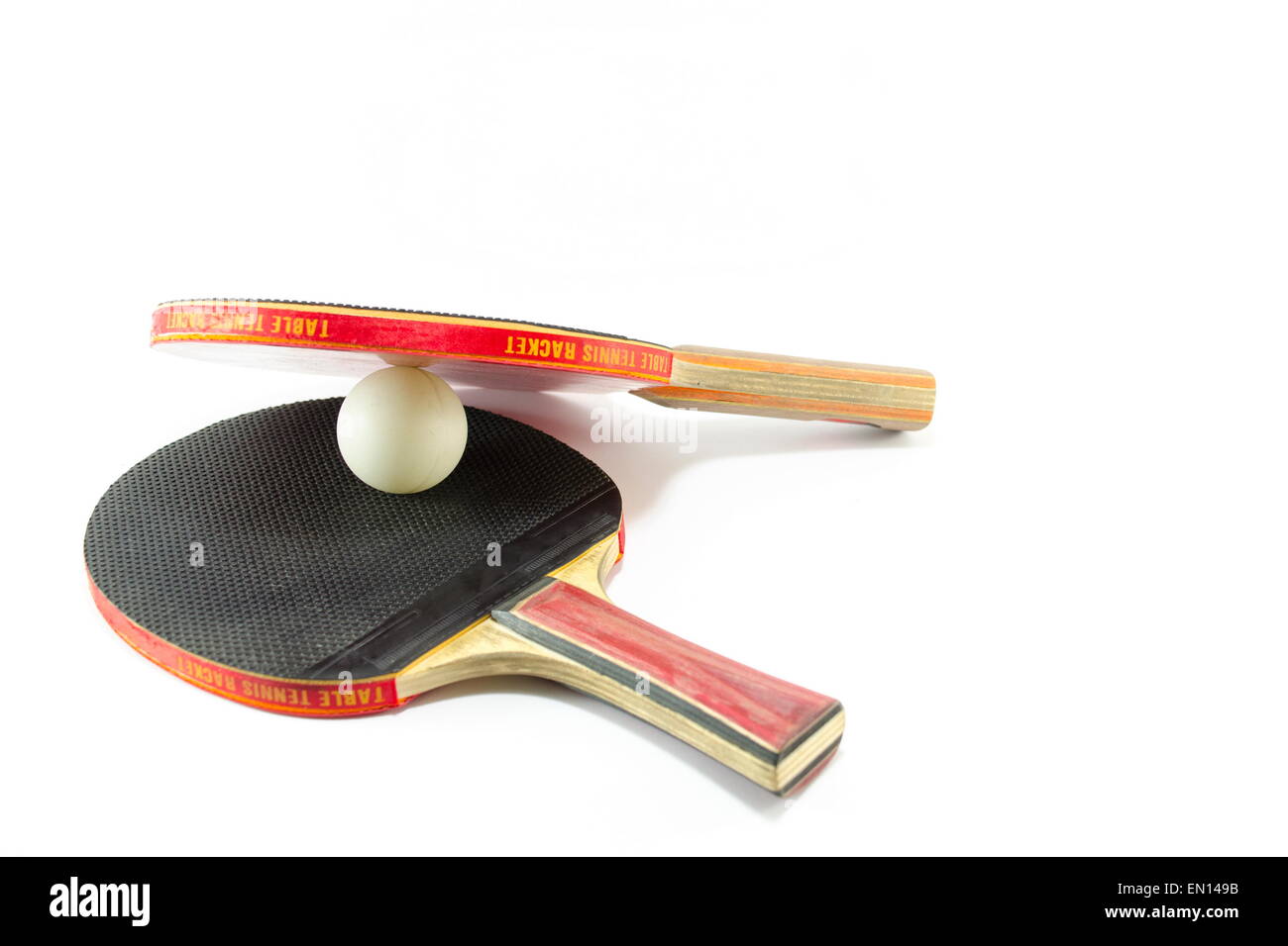 Zwei Tischtennis-Schläger und einen Ball, isoliert Stockfoto