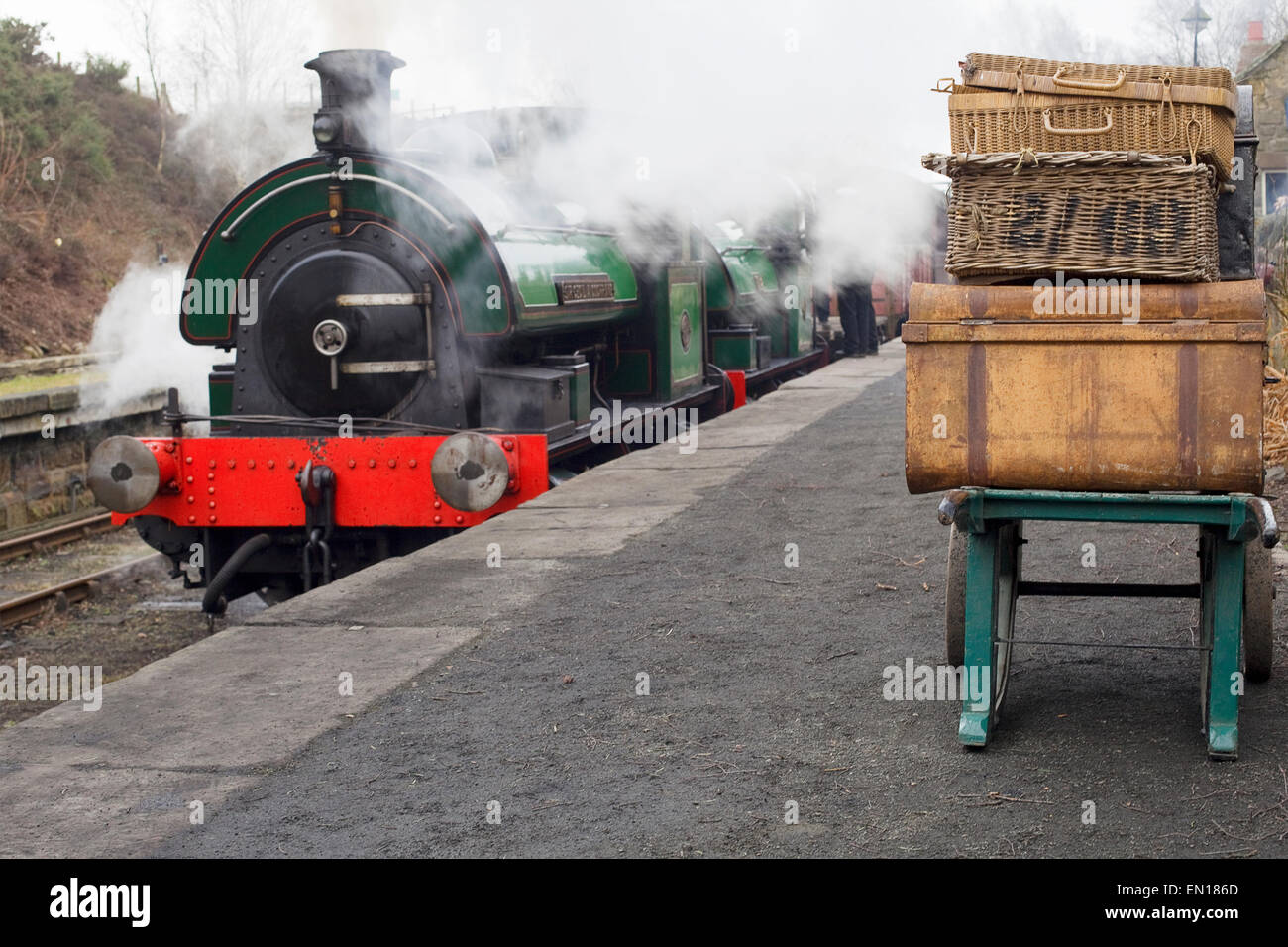 Alten Gepäck und Dampfmaschine auf der Plattform an Andrews House Station auf die Tanfield Eisenbahn, Durham. Stockfoto