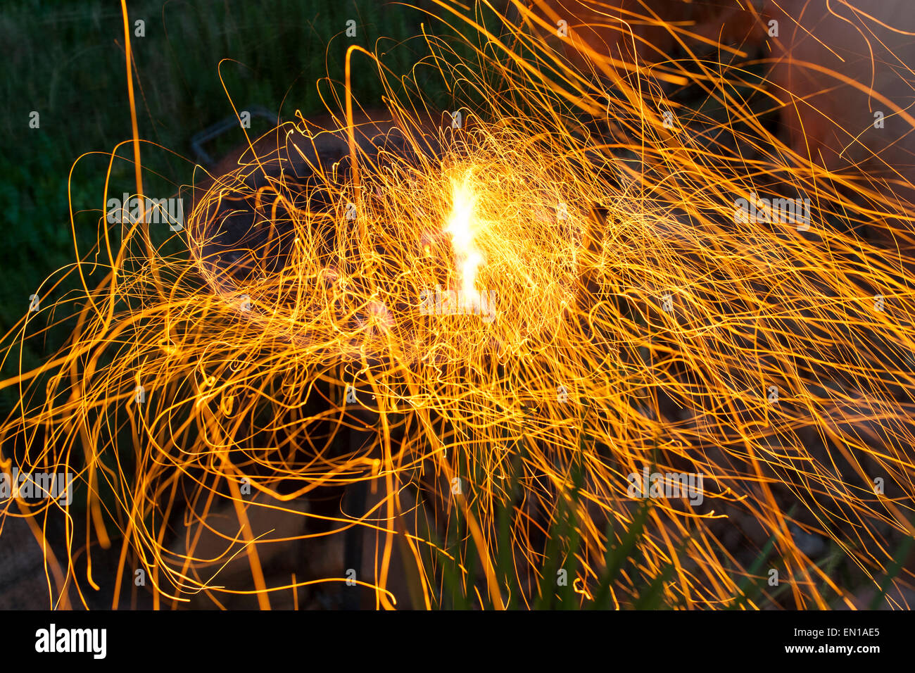 Langzeitbelichtung von Funken fliegen aus einem Grill Feuer. Stockfoto