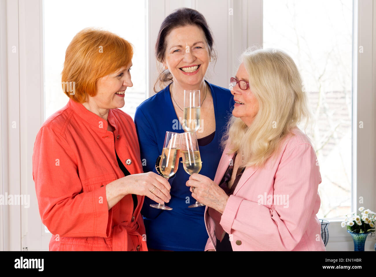 Hautnah. Drei wiedervereinigten Mom es Best Friends in trendigen Outfits Gläser Weißwein genießen. Stockfoto