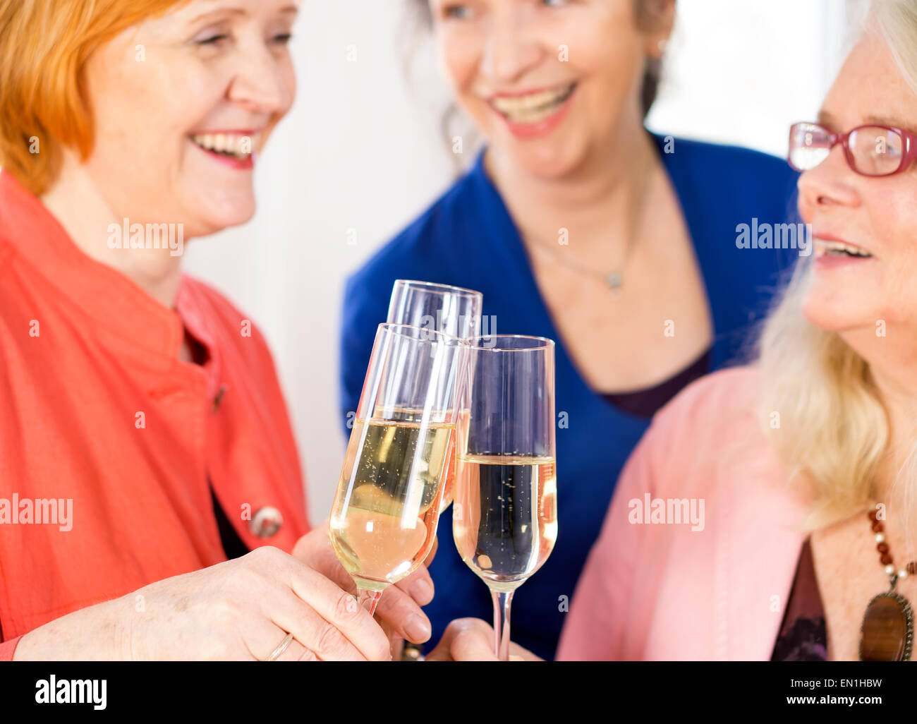 Brille von leckeren Weißwein warf durch glückliche Erwachsene Freundinnen etwas zu feiern. Stockfoto