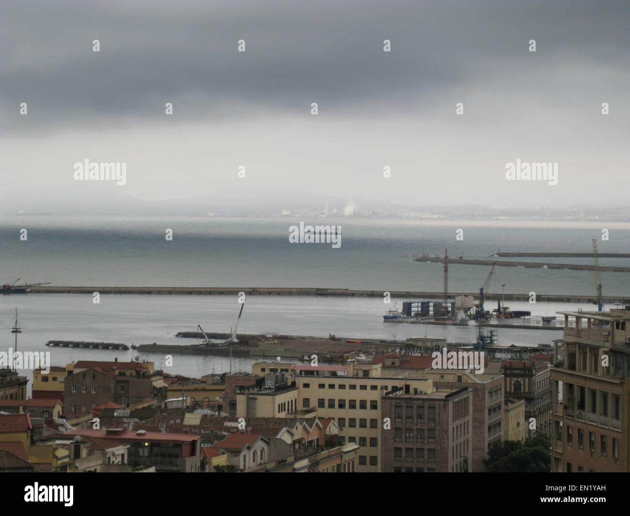 Von Cagliari Skyline mit Gebäuden, Hafen, Meer und düsteren grauen bewölktem Himmel in Sardinien Stockfoto