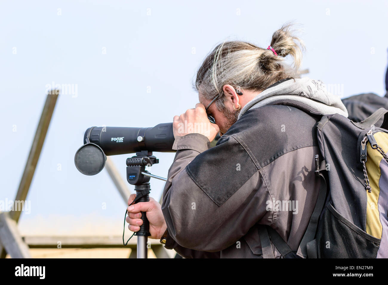 Bejershamn, Schweden - 25. April 2015: Unbekannte männliche Vogelbeobachter mit Spektiv finden interessante Vögel zu beobachten. Person, von der Seite gesehen und hinter von der Hüfte aufwärts. Bejershamn ist ein geschütztes Naturschutzgebiet bekannt für seine Vogelwelt. Stockfoto