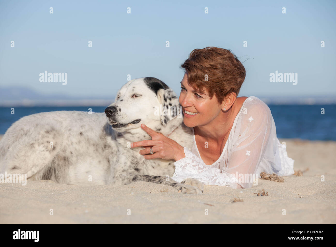 Frau mit alt Mischling Hund am Strand Stockfoto