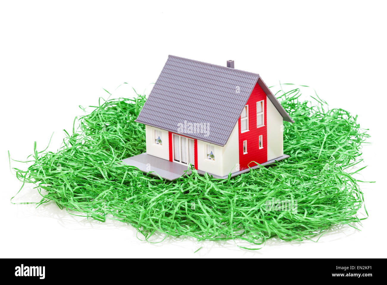Musterhaus auf dem grünen Rasen isoliert auf weißem Hintergrund Stockfoto