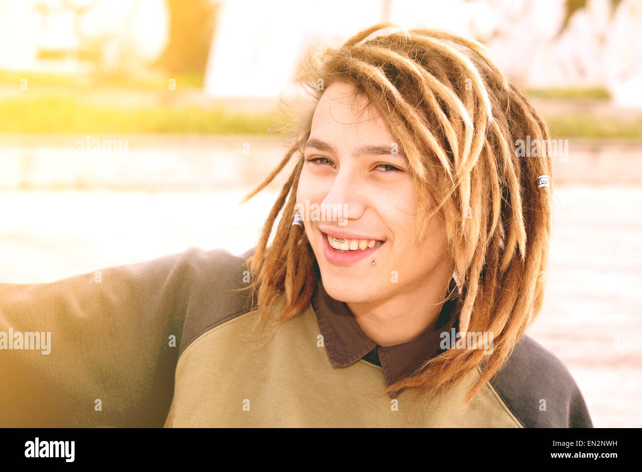 Lifestyle-Porträt eines jungen Mannes mit Rasta Haare warmen Tönen Filter angewendet Stockfoto