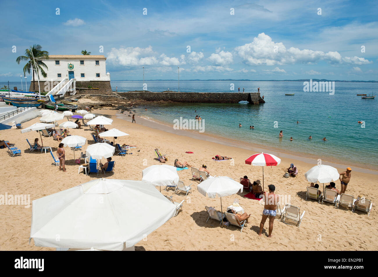 Strand Porto da Barra in Salvador Bahia Brasilien bestreut mit Beachgoers vor kolonialen Fort Santa Maria Stockfoto
