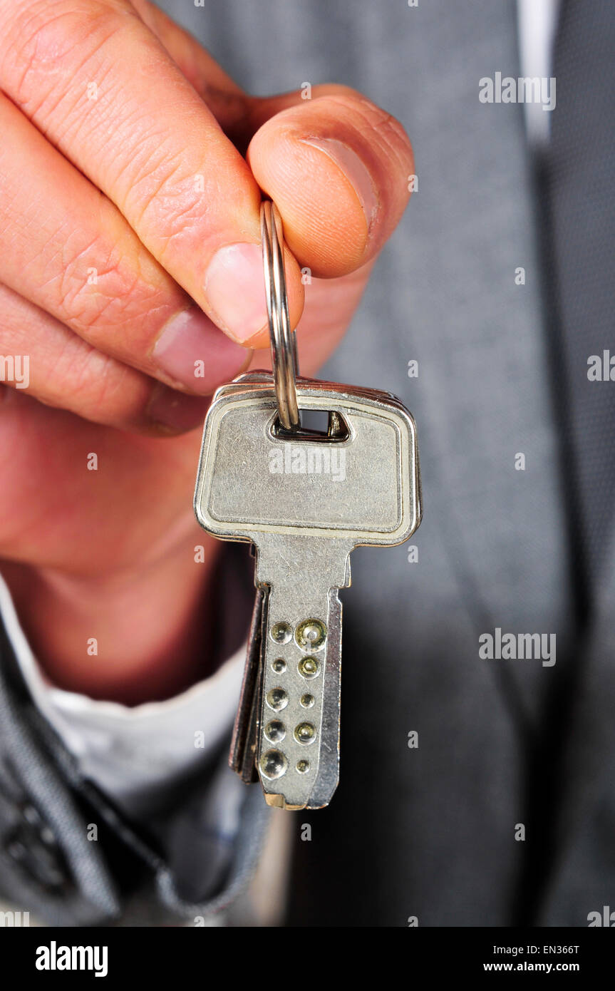 ein Mann trägt einen Anzug mit einem Schlüsselbund in der hand Stockfoto