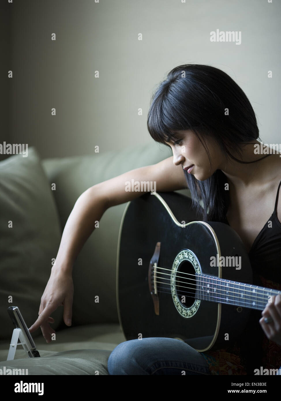 Frau tuning Gitarre mit Metronom Stockfotografie - Alamy