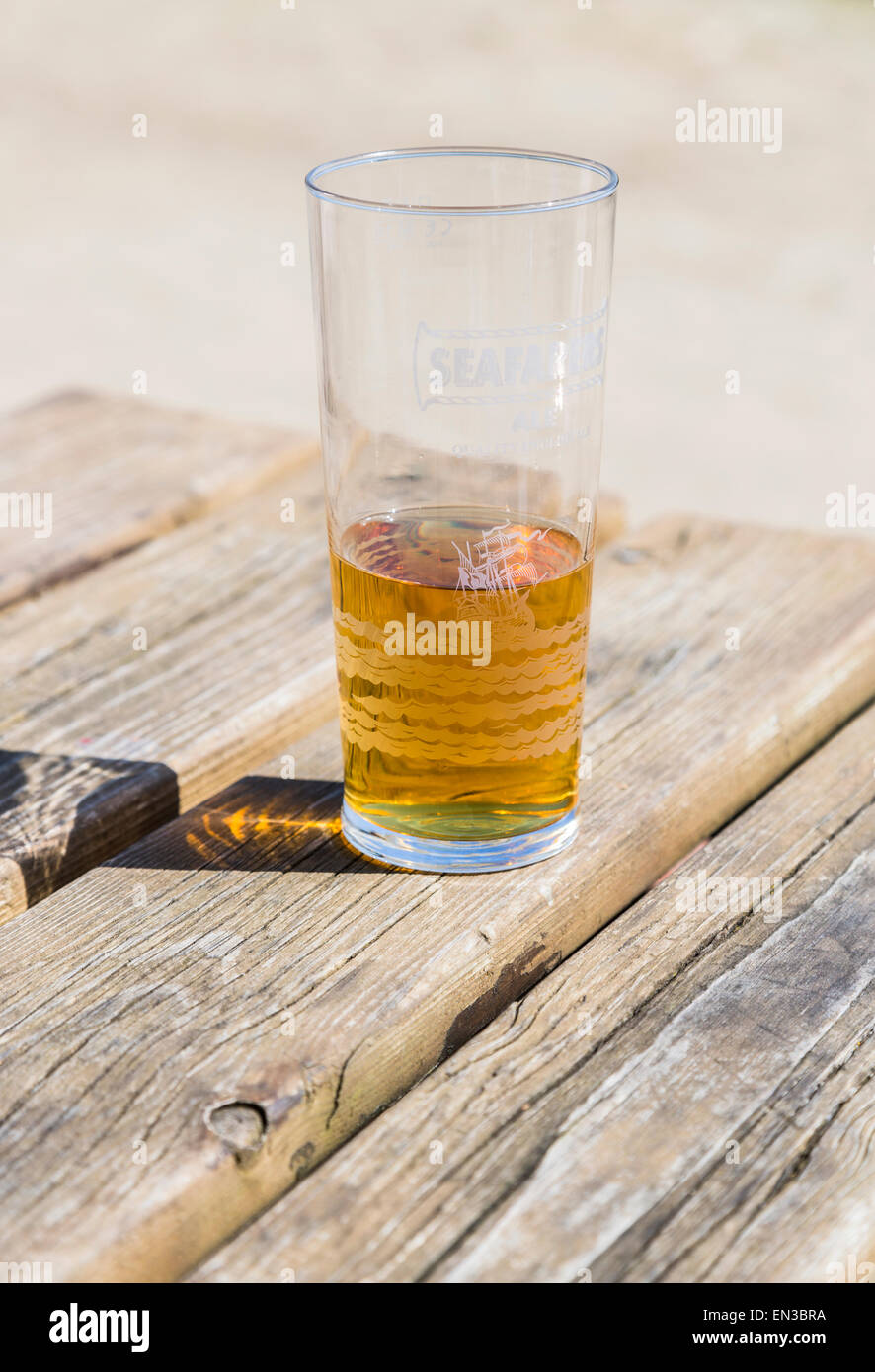 Halb leer oder halb voll, ein Glas Bier oder Radler auf einem hölzernen Pub-Tisch, Glas markiert Seemanns Ale Stockfoto