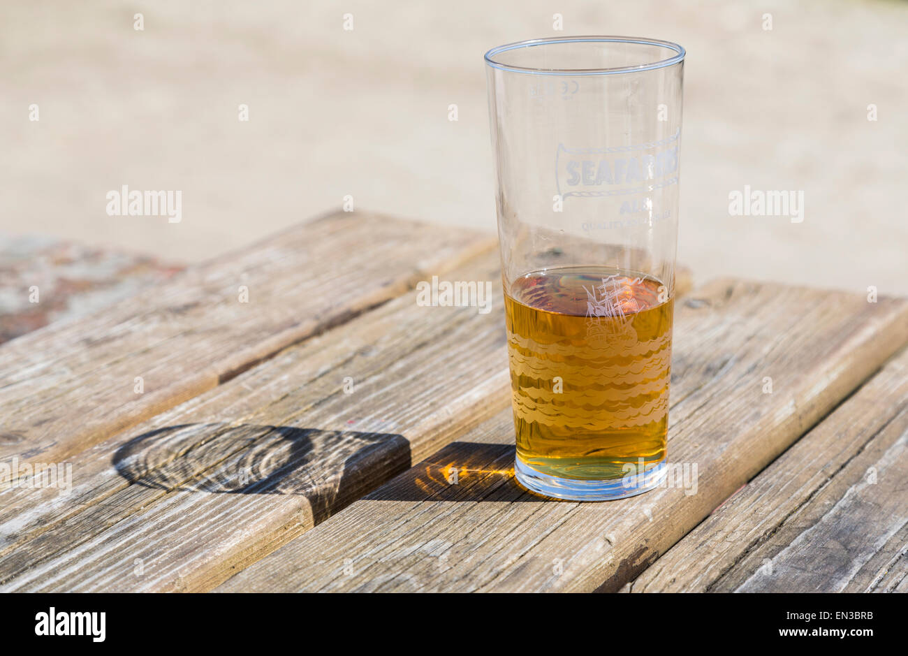 Halb leer oder halb voll, ein Glas Bier oder Radler auf einem hölzernen Pub-Tisch, Glas markiert Seemanns Ale Stockfoto