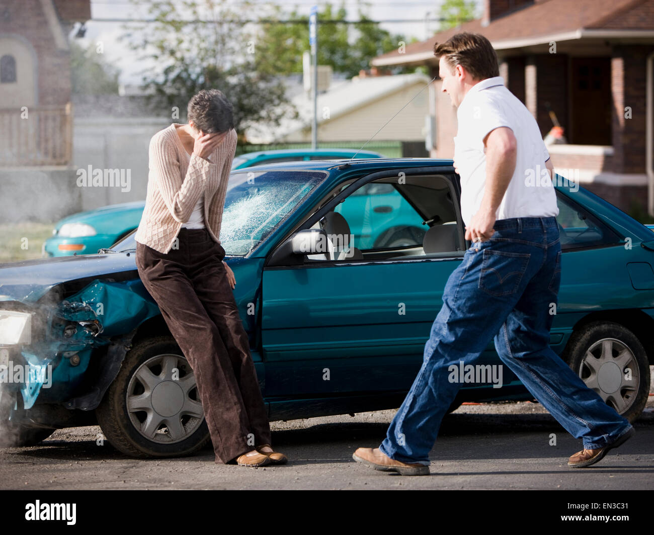 Mann hilft einer Frau nach einem Autounfall Stockfoto