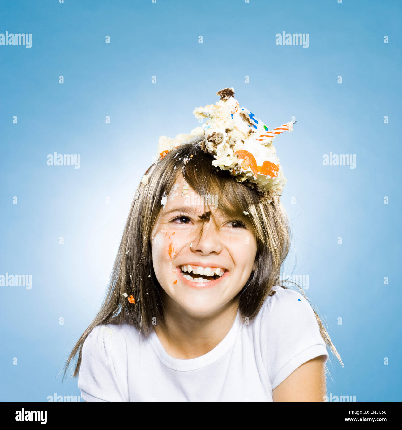 Mädchen mit Geburtstagstorte auf dem Kopf Stockfoto
