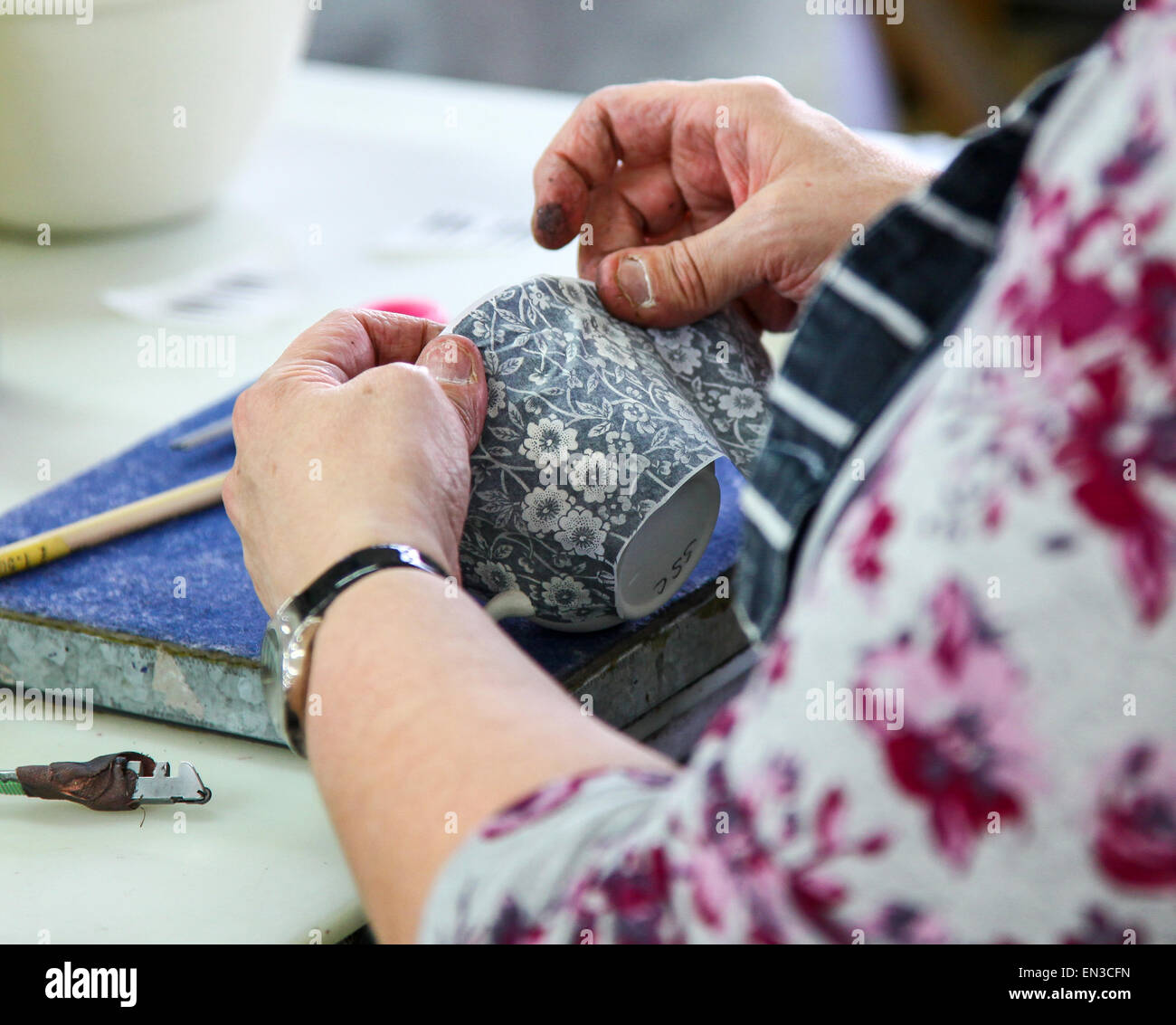 Eine Frau, die eine Übertragung auf eine Tasse an Burleigh Middleport Keramikfabrik Stoke-on-Trent North Staffordshire England UK anwenden Stockfoto