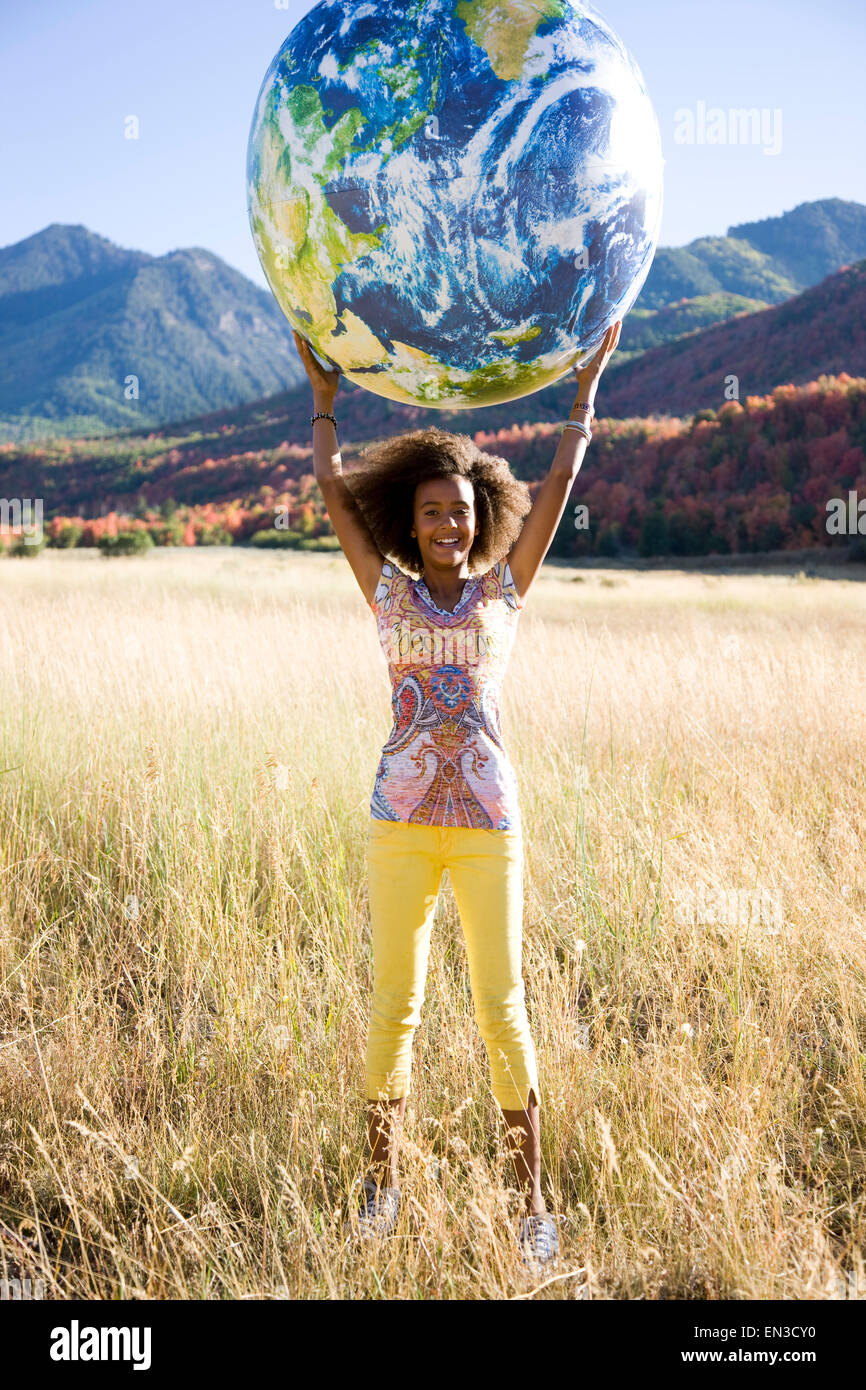 USA, Utah, South Fork, Portrait eines Mädchens (12-13) halten aufblasbare Kugel-Kugel auf Wiese Stockfoto