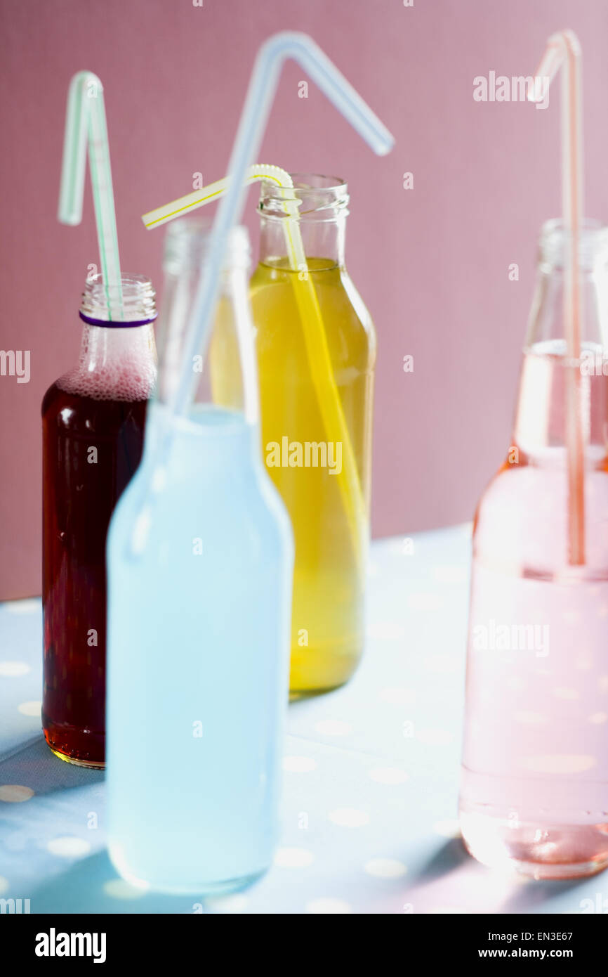 Vier Soda-Flaschen mit einem Strohhalm Stockfoto