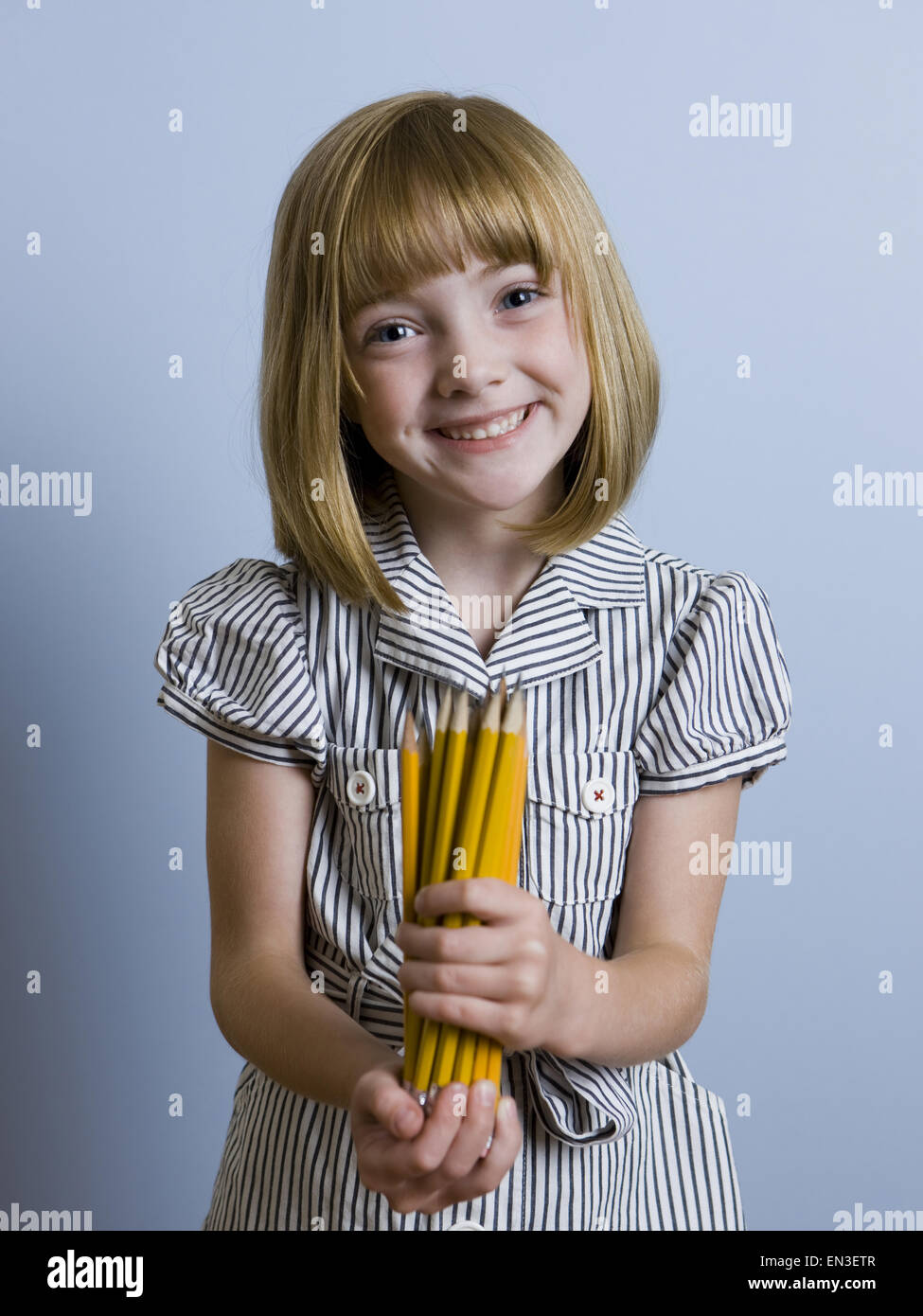 Mädchen hält ein Bündel Bleistifte Stockfoto