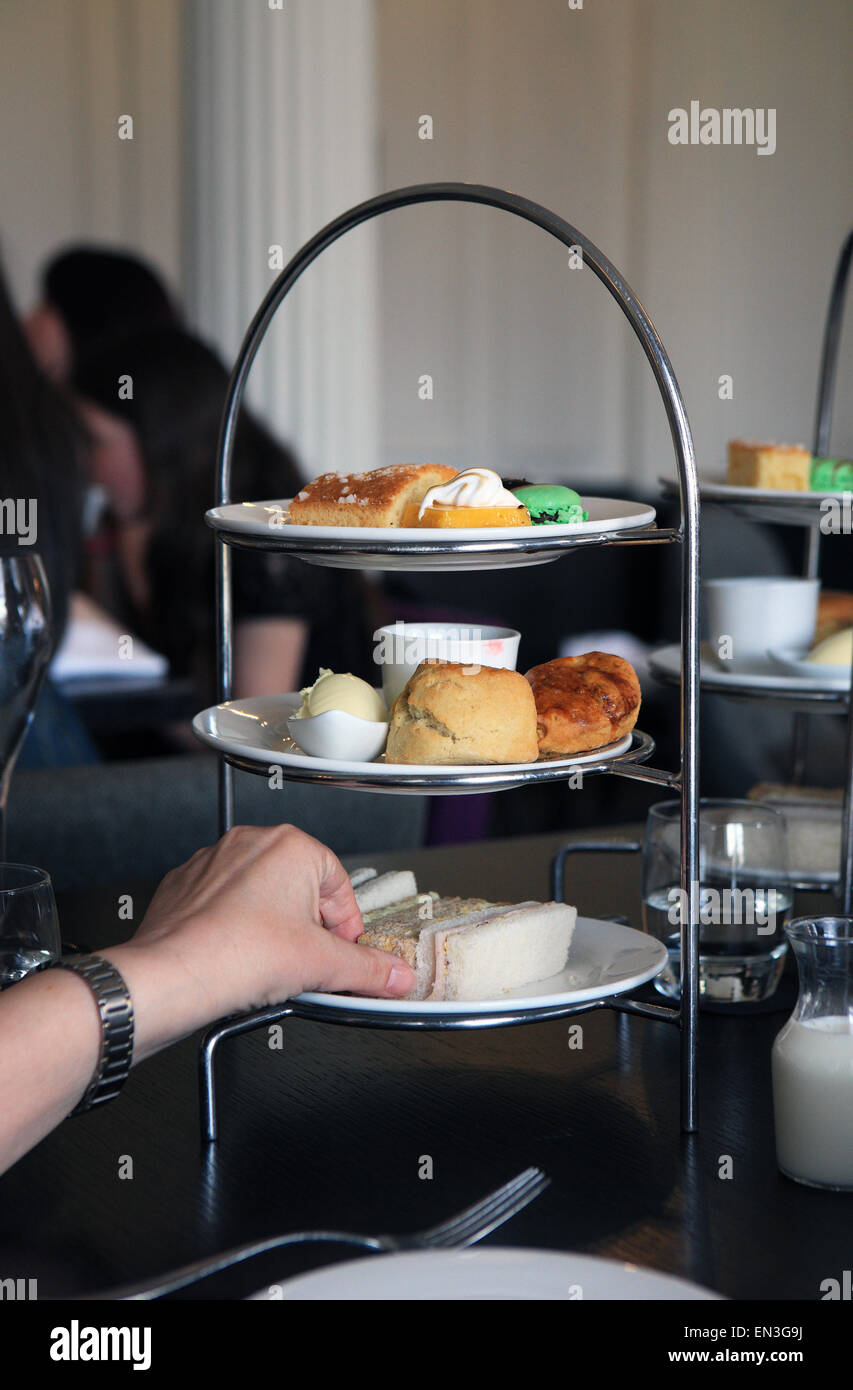 Eine weibliche Hand Griff nach einem Sandwich am Nachmittag Tee stand im Blythswood Hotel in Glasgow Schottland Stockfoto