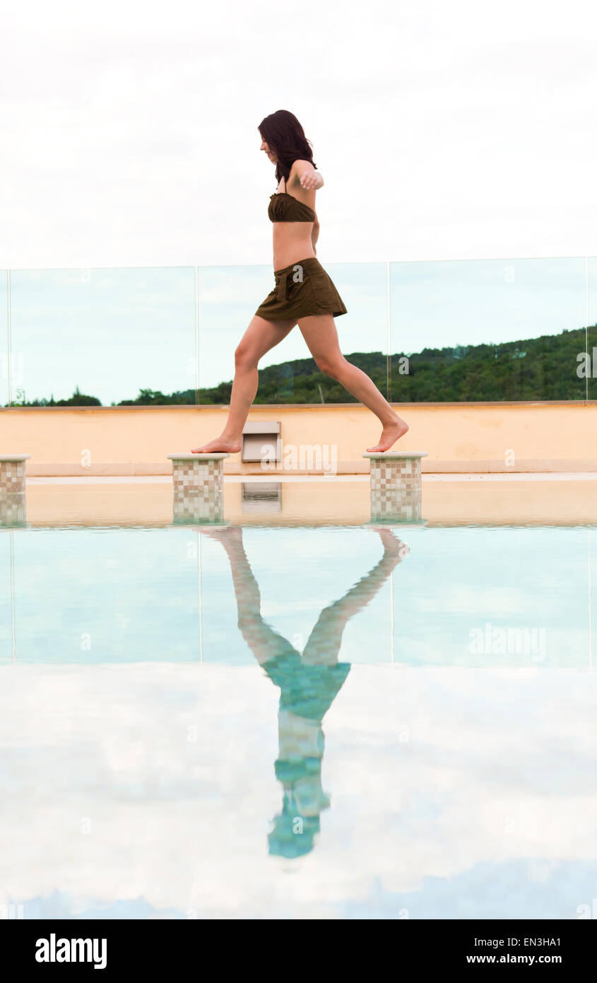 Italien, Toskana, Frau Balanceakt am Rande des Schwimmbad Stockfoto