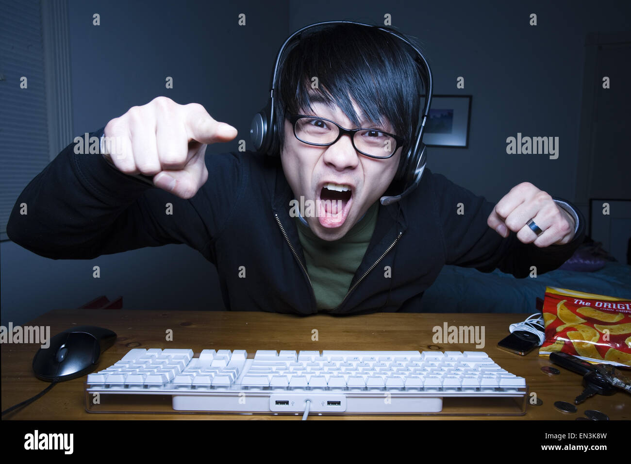 Mann mit Kopfhörer Fäuste machen und sitzen am keyboard Stockfoto
