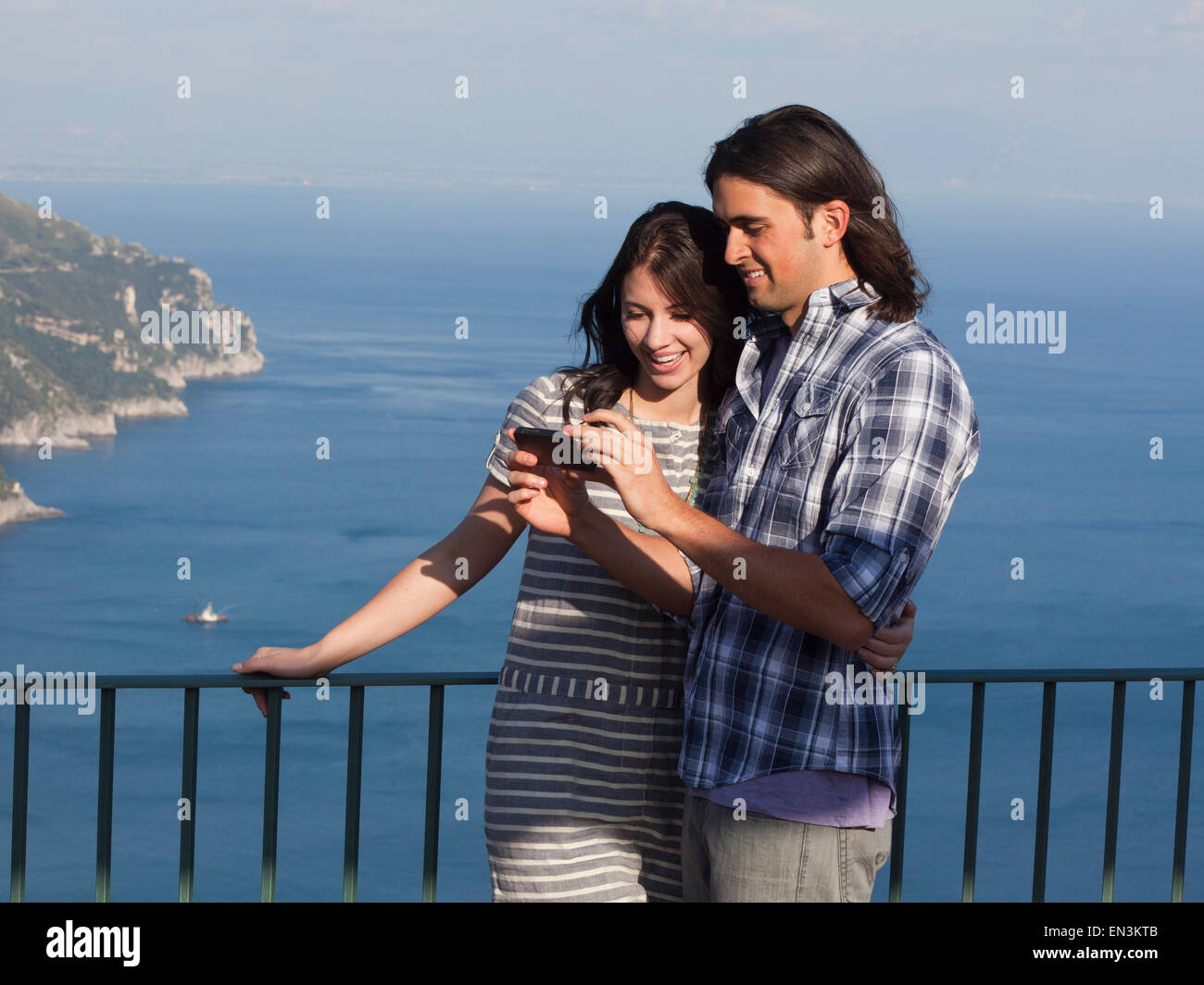 Ravello, Italien Palazzo Sasso, Porträt von lächelnden paar mit Smartphone mit Küste im Hintergrund Stockfoto