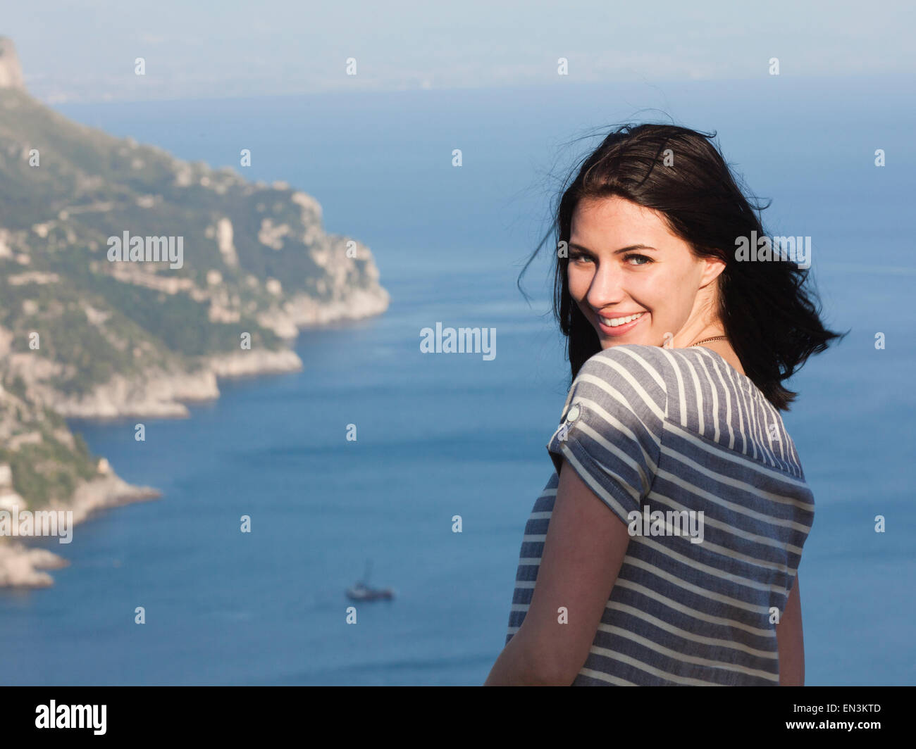 Italien, Ravello, Palazzo Sasso, Portrait von lächelnden Frau mit Küste im Hintergrund Stockfoto