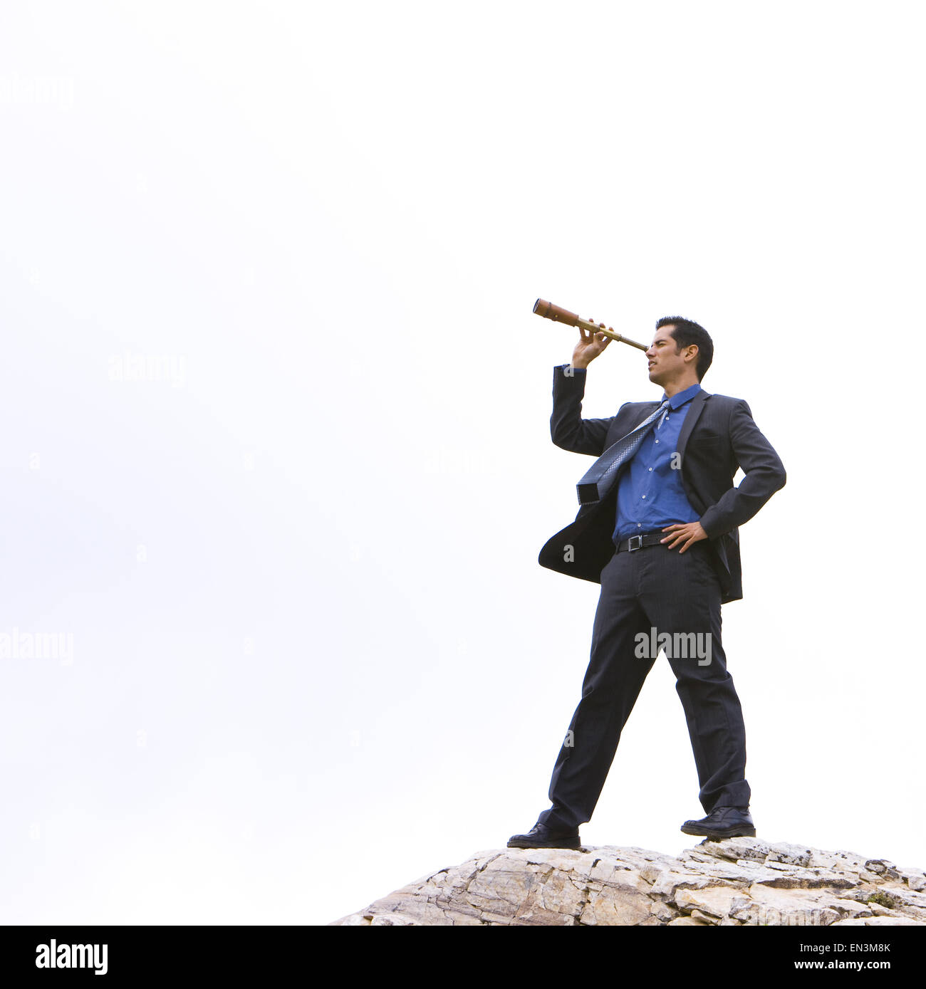 Geschäftsmann auf einem Gipfel mit einem Fernglas Stockfoto