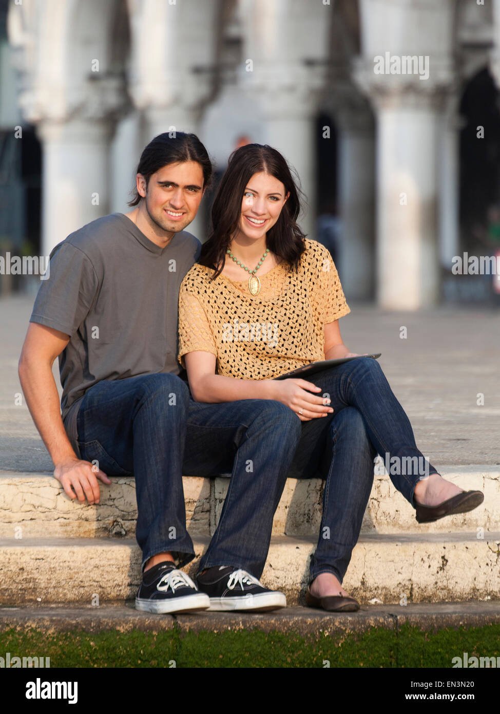Italien, Venedig, Porträt des jungen Paares sitzen auf Stufen auf dem Markusplatz Stockfoto