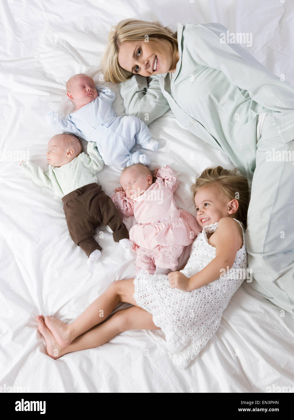 Frau im liegen mit ihren vier Kindern Stockfoto