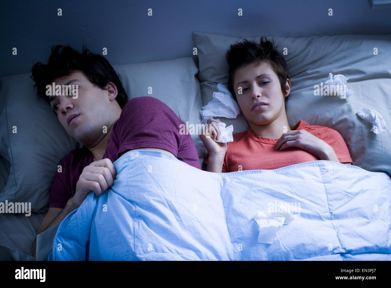 Mann mit im Bett mit Frau Nase mit Gewebe Stockfoto