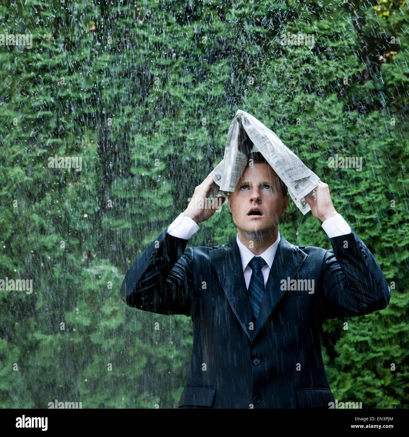 Mann in einem Anzug steht neben einem sprinkler Stockfoto