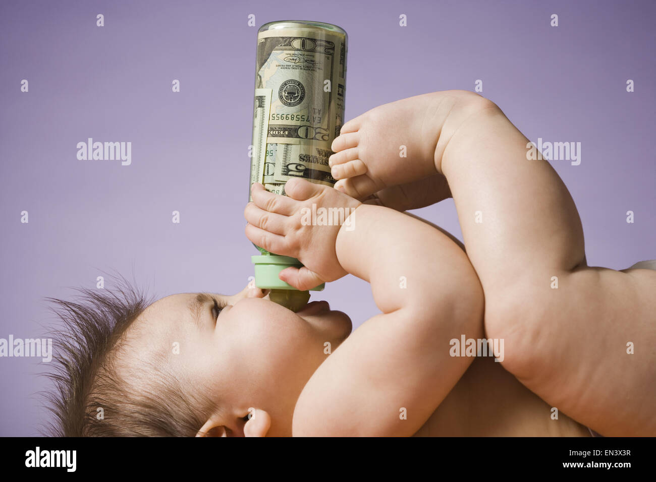 Baby trinken aus der Flasche mit US-Währung in es Stockfoto