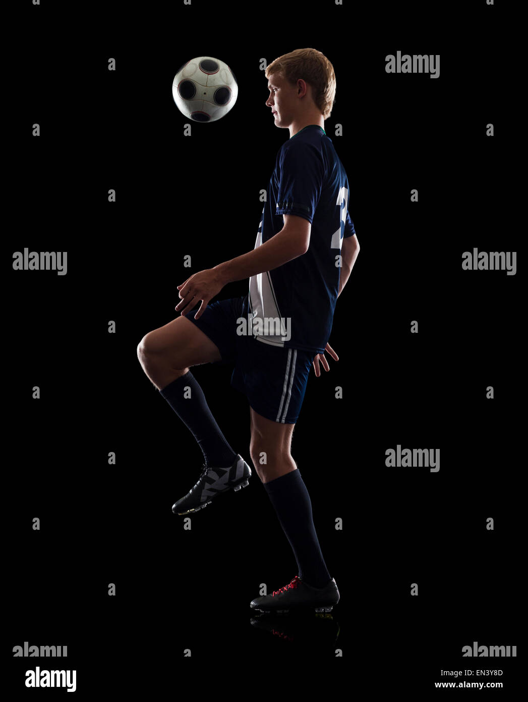 Studioportrait von Teenager (16-17) mit Fußball Stockfoto