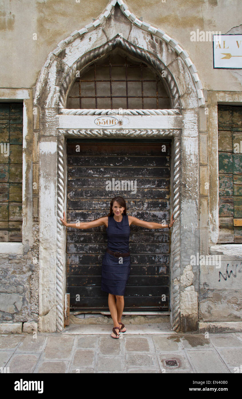 Italien, Venedig, Reife Frau, die gegen alte Holztüren Stockfoto